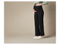 Pantalon large noir plissé avec des baskets blanches.