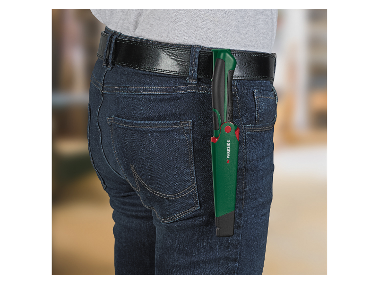 Scie pliante Parkside dans la poche arrière d'un jean.