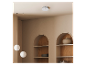 Détecteur de fumée sur un plafond clair avec niches décoratives et lampes suspendues.