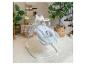 Balançoire pour bébé avec siège à motifs dans un salon avec plantes et décor.