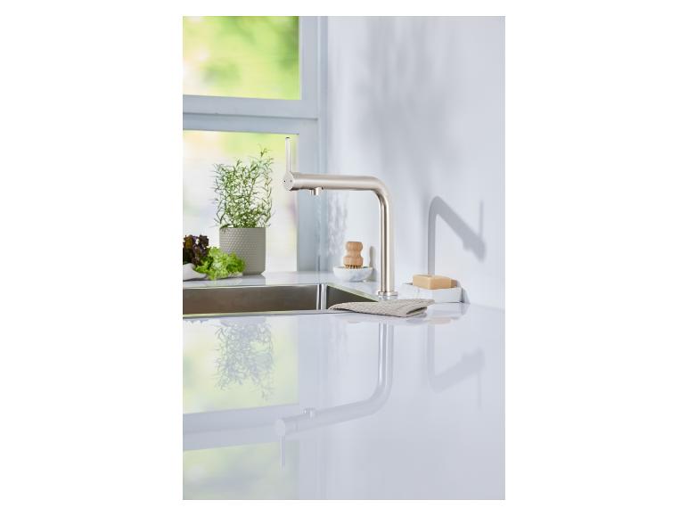 Un robinet de cuisine moderne et élégant en nickel brossé sur un comptoir blanc.
