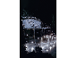 Banc décoré de guirlandes lumineuses LED blanches à l'extérieur la nuit.