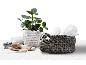 Panier gris avec serviettes, pot blanc avec plante et savons sur un plateau en bois.