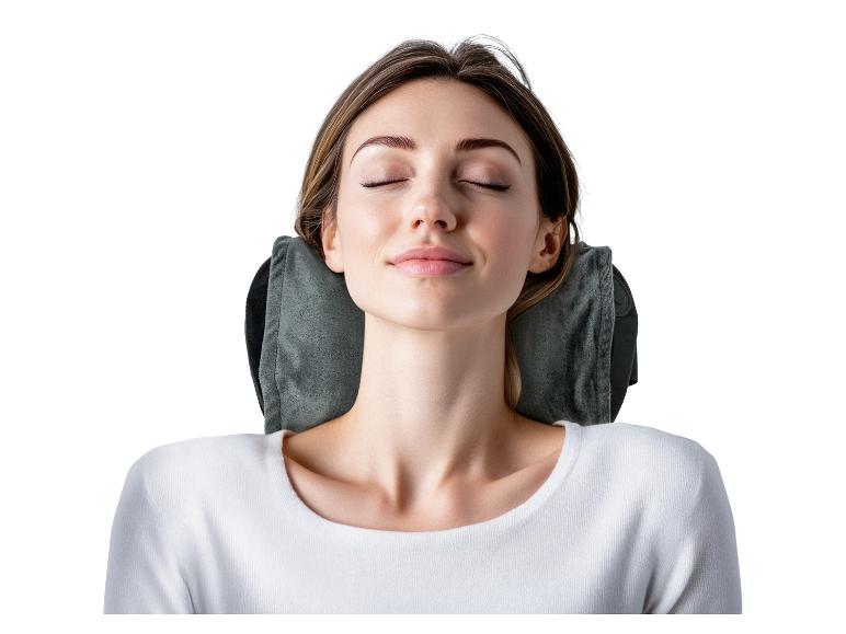 Femme se reposant les yeux fermés, avec un oreiller de voyage gris.