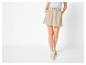 Jupe-short beige femme avec cordon de serrage et chemise rayée claire.