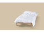 Couette blanche sur un lit en bois.