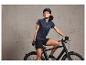 Une femme en casque et en tenue de vélo sur un vélo noir.