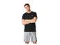 Homme en t-shirt de sport noir et short de sport gris, bras croisés