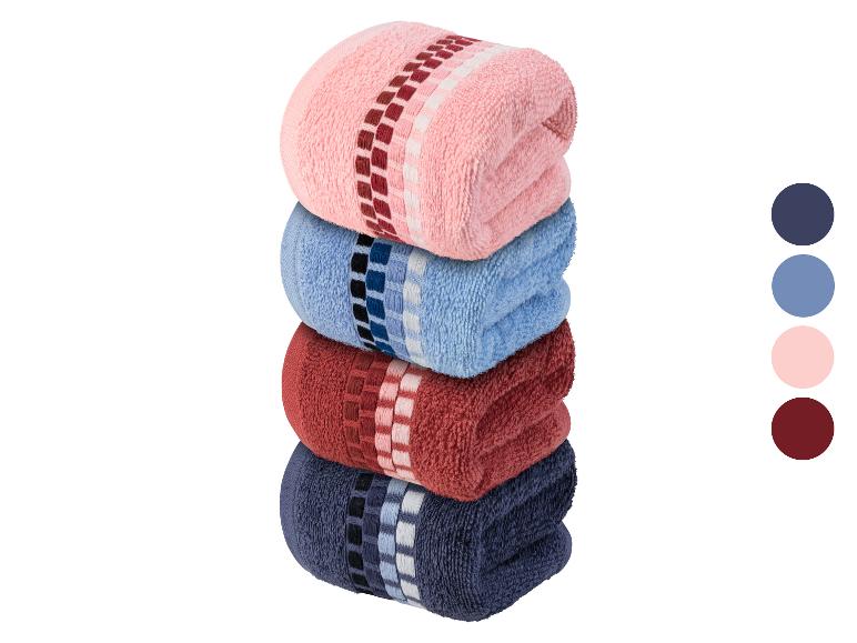 Une pile de quatre serviettes de toilette dans différentes couleurs.