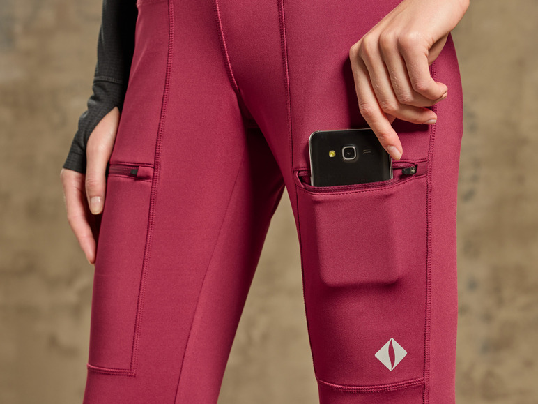 Une femme porte un legging rouge avec un téléphone dans la poche