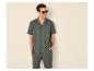 Homme souriant en chemise et short en coton verts, lunettes de soleil.