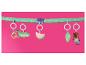 Jouets suspendus pour bébé : crocodile, pastèque, feuille et ours en peluche sur une barre verte à pois.