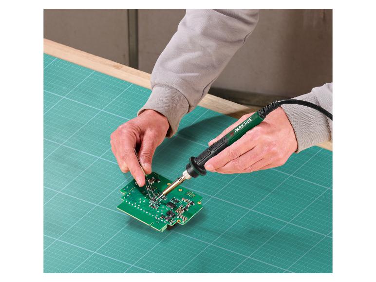 Une personne utilisant un fer à souder Parkside pour travailler sur une carte de circuit.