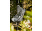 Un fauteuil suspendu gris avec coussin dans un jardin.