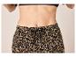 Femme en pantalon imprimé léopard avec cordon de serrage à la taille et soutien-gorge noir.