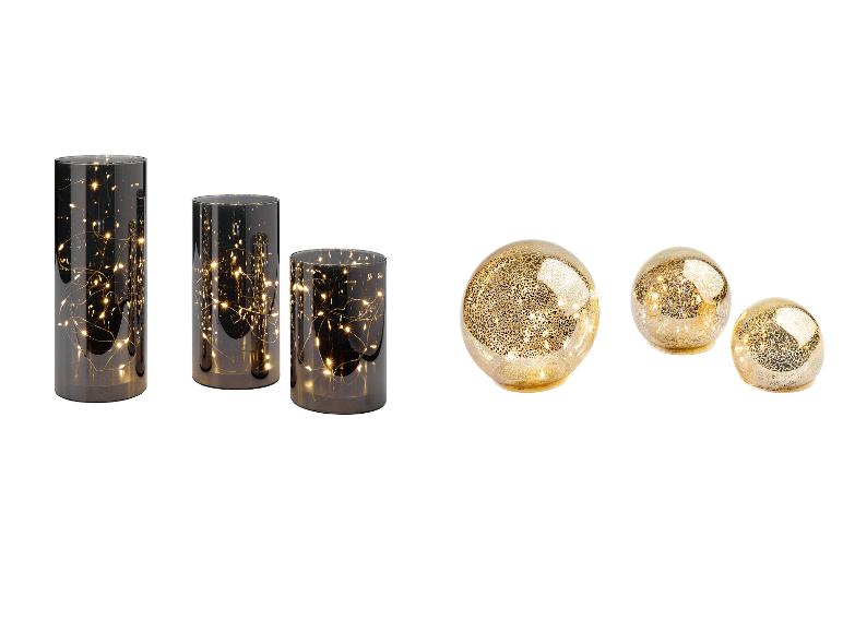 Trois vases cylindriques avec des lumières et trois sphères décoratives dorées.