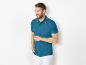 Polo homme bleu marine à col contrasté et pantalon blanc.