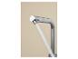 Robinet chromé avec jet d'eau sur fond beige.