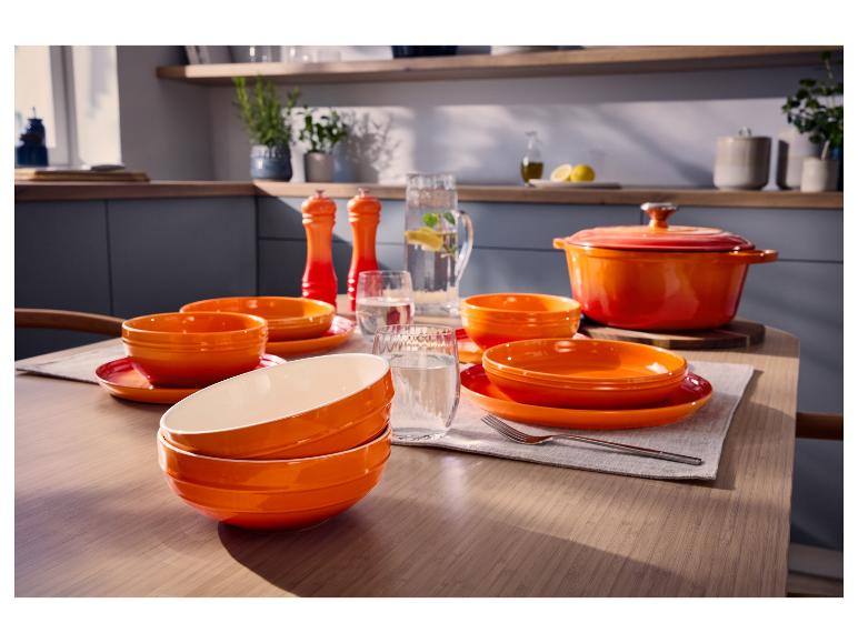 Cocotte en fonte orange SILVERCREST® et vaisselle sur une table dressée.