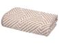 Serviette pliée beige et blanche à motifs