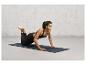 Une femme fait des pompes sur un tapis de yoga foncé avec la marque 'TRUE SUPPORT'.