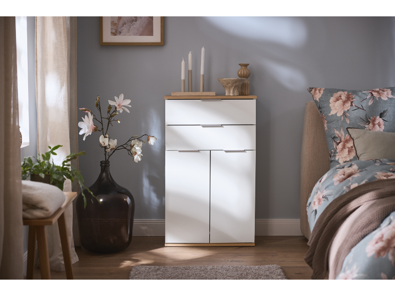 Commode blanche moderne dans une chambre chaleureuse.