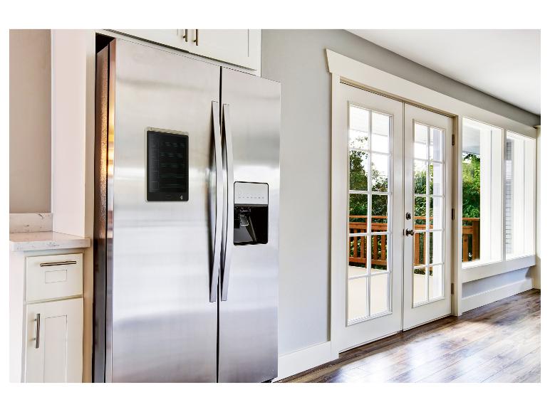 Réfrigérateur acier inoxydable avec tablette mémo numérique dans une cuisine moderne.