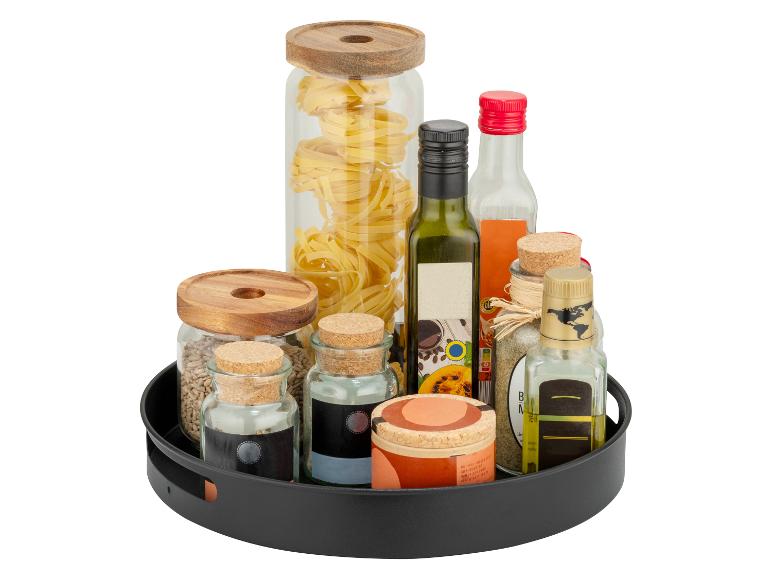 Plateau tournant avec pâtes, huile, vinaigre et épices dans des bocaux et bouteilles en verre.