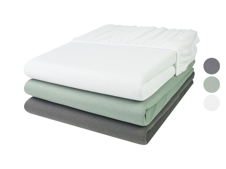 Un ensemble de draps blancs, verts et gris.
