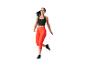 Femme en leggings et top de sport orange et noir sautant.