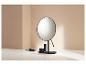Un miroir de maquillage au design moderne avec des accessoires de maquillage.