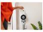 Personne branchant un aspirateur balai sans fil blanc fixé au mur.