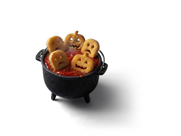 Formes de pommes de terre d'Halloween dans un chaudron de sauce tomate fumante.