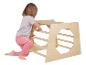 Un enfant grimpe sur une aire de jeux en bois.