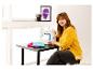 Femme souriante assise à une table avec une machine à coudre et des tissus.