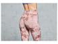 Femme portant un legging rose avec un motif abstrait.
