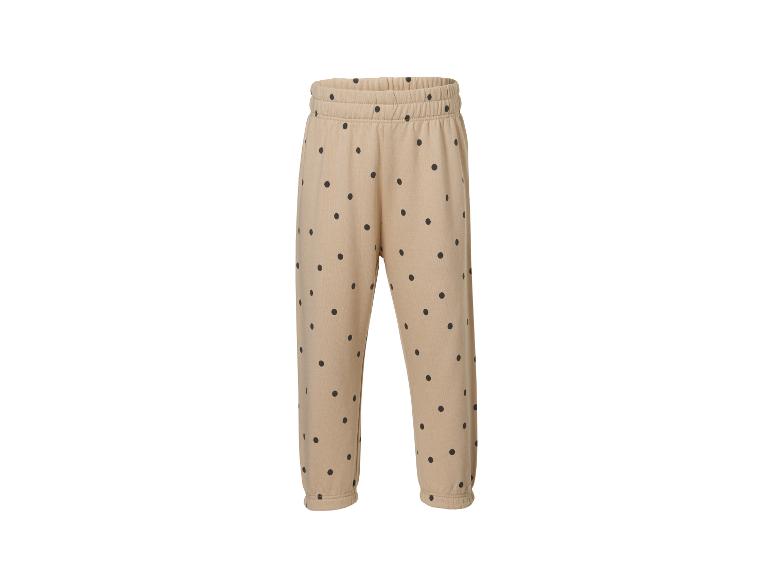 Pantalon de jogging beige à pois noirs, taille élastique et chevilles resserrées.