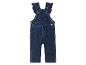 Une salopette en jean pour bébé avec des détails en forme de cœur.