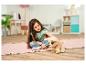 Une petite fille joue avec un chiot en peluche.