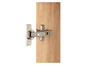 Gros plan d'une charnière fixée à une porte en bois.