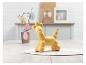 Un chien ballon jaune sur une table blanche avec un vase d'œufs de Pâques.