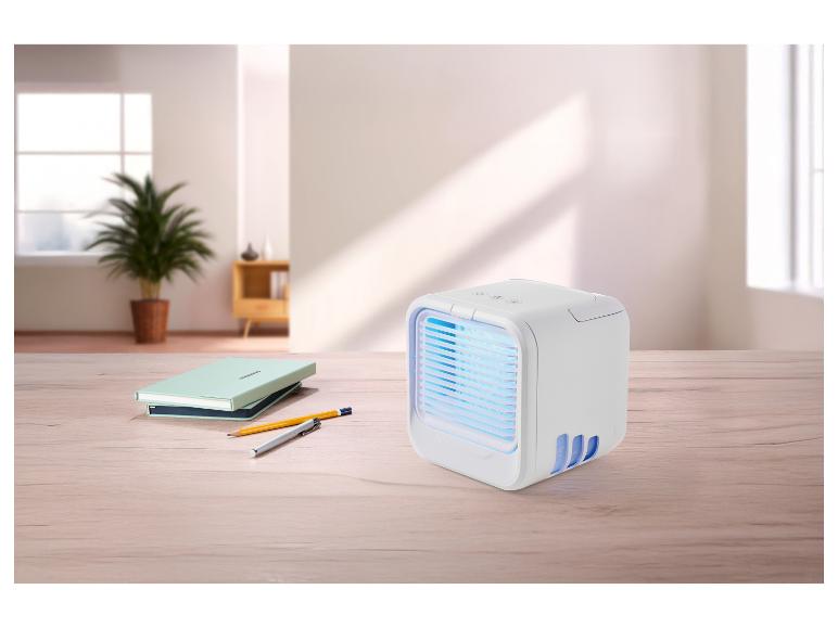 Refroidisseur d'air portable avec lumière bleue sur un bureau en bois avec cahiers et stylos