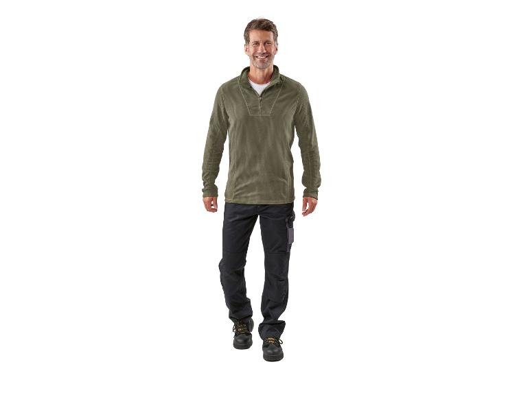 Homme portant un sweat-shirt en polaire vert et un pantalon de travail noir