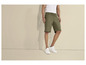 Un homme porte un short vert et des baskets blanches.