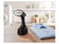 Défroisseur vapeur portable noir et chemise bleue pliée sur une table en bois