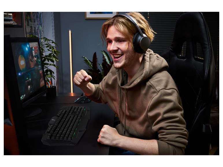 Un jeune homme joue sur ordinateur avec un clavier et une souris de gaming TRONIC®.
