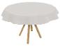 Nappe blanche ronde sur table en bois.