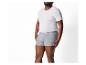 Un homme portant un t-shirt blanc et un boxer gris.