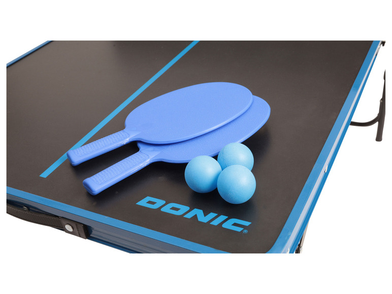 Deux raquettes de ping-pong bleues et trois balles sur une table de ping-pong Donic.