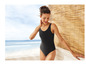 Une femme en maillot de bain noir sur la plage.